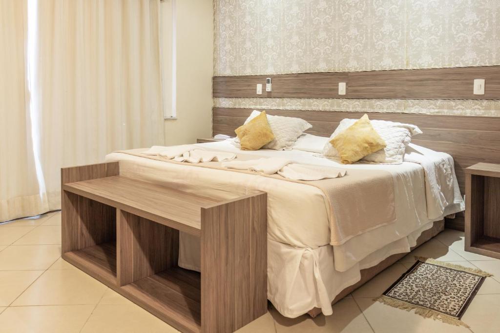 una camera con un grande letto con testiera in legno di Hotel Bel Air a Teresópolis
