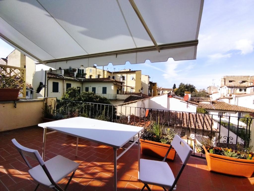 balcón con mesa, sillas y vistas en Serragli Flat Firenze, en Florencia