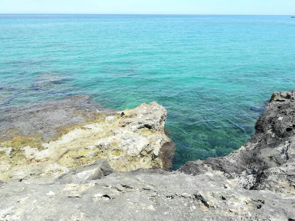 a view of the ocean from a rocky shore at La Racioppola in Ostuni