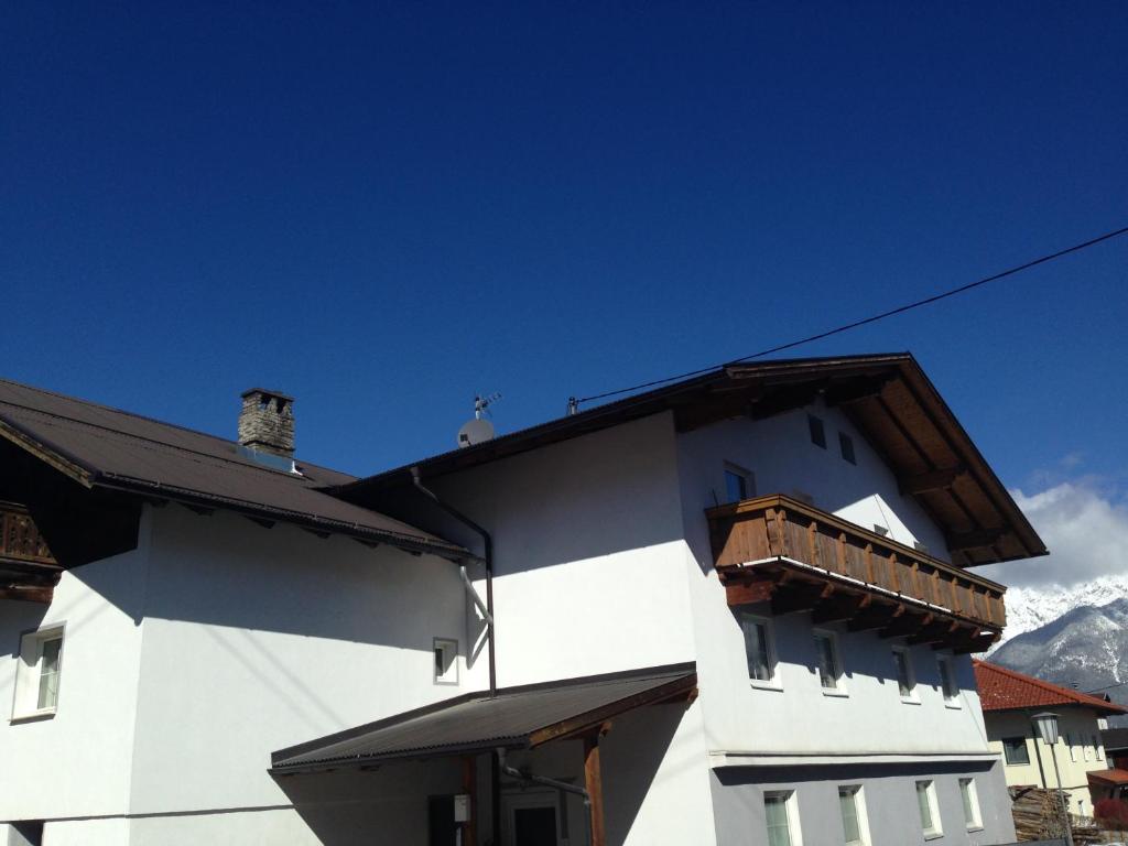 a white building with a balcony on the side of it at Landhaus Grünfelder in Oberperfuss