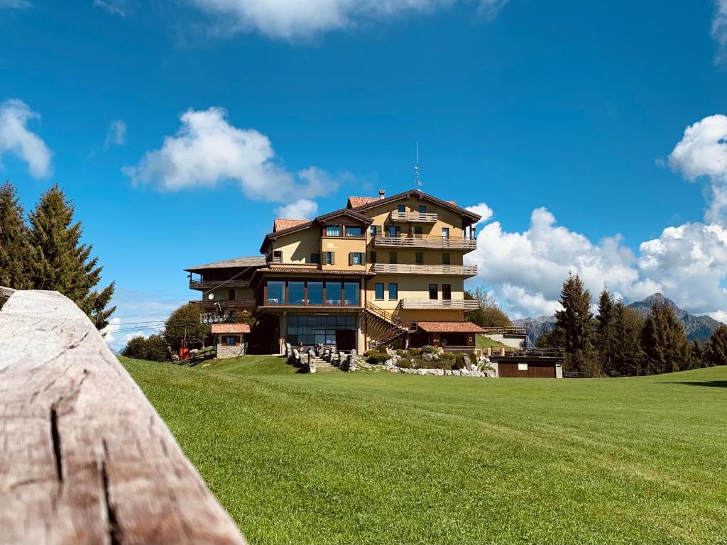 una casa grande sentada en la cima de un exuberante campo verde en Resort Monte Poieto, en Aviatico