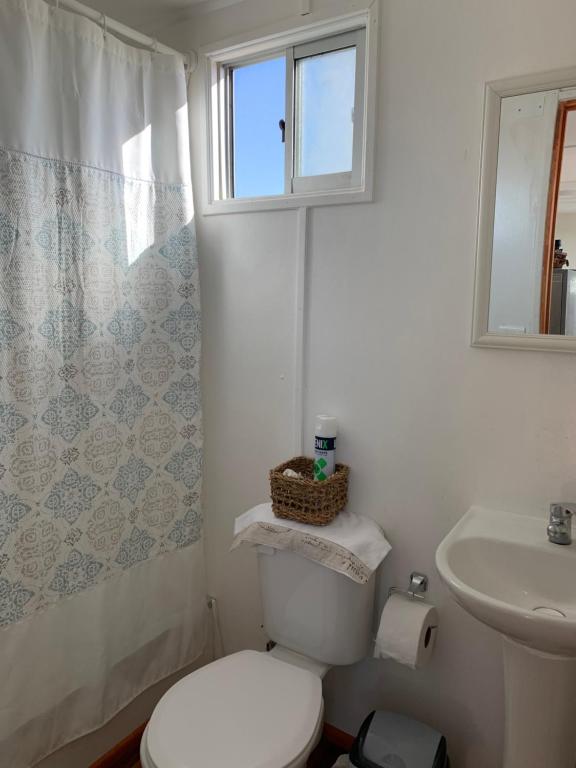 a white bathroom with a toilet and a sink at Cabañas ecológicas Tongoy in Tongoy