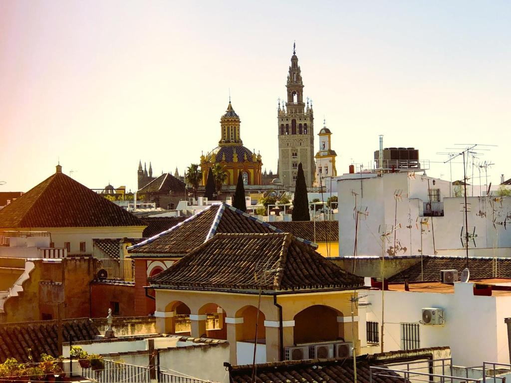 Blick auf eine Stadt mit Gebäuden und einem Uhrturm in der Unterkunft Apartamento San Clemente in Sevilla