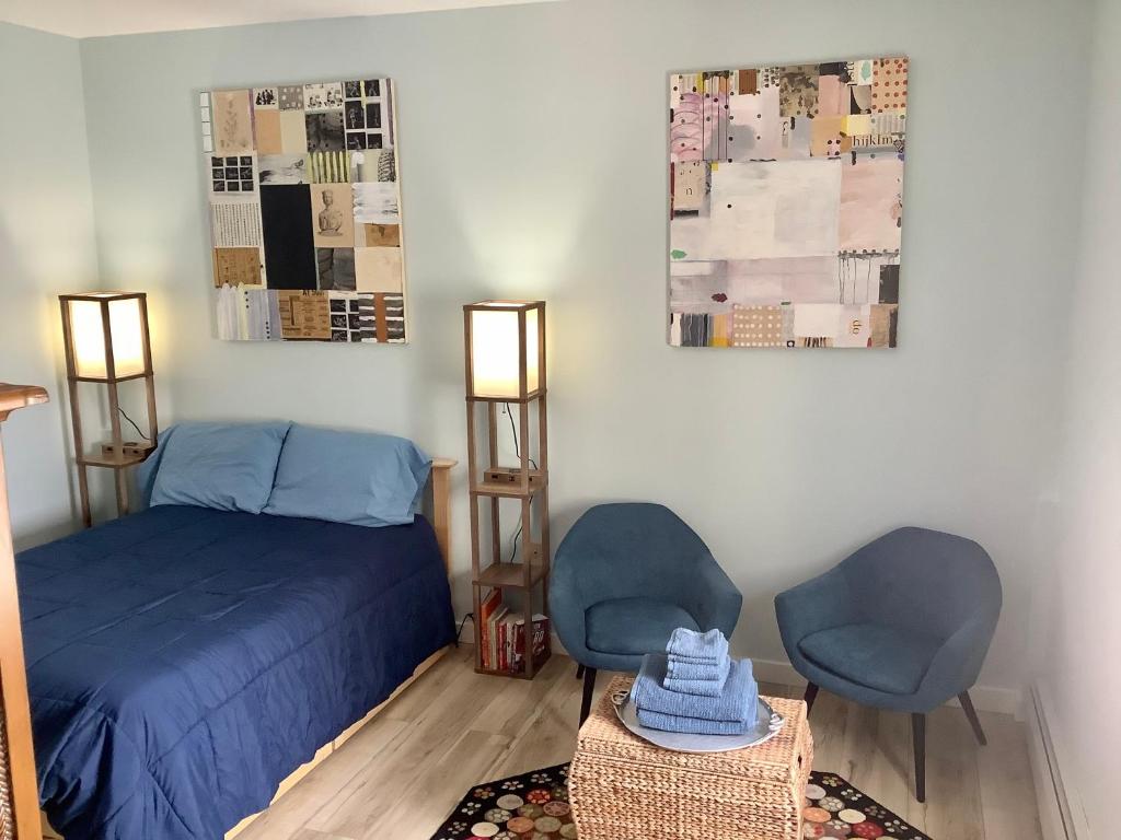 1 dormitorio con 2 sillas azules y 1 cama en Hasty House Studio, en Auburn