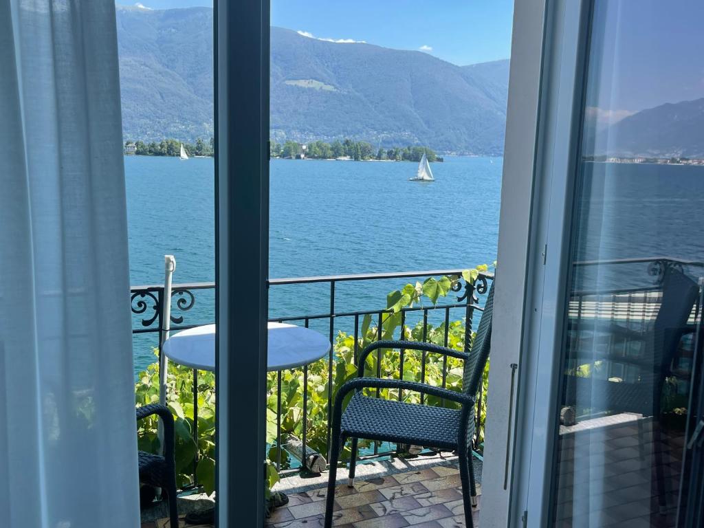 a balcony with a view of the water and a sailboat at Art Hotel Ristorante Posta Al Lago in Ronco s/Ascona - Porto Ronco