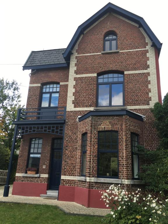 een rood bakstenen huis met zwarte ramen bij Overijse’s cosiest double room in Overijse