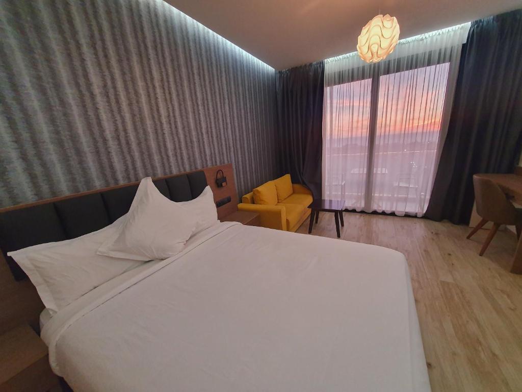 a bedroom with a large white bed and a chair at Surf One Hotel in Agadir