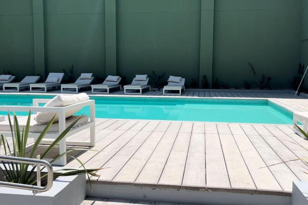 una piscina con una fila de sillas junto a ella en Torre Bóreas, tu viento a favor en Buenos Aires