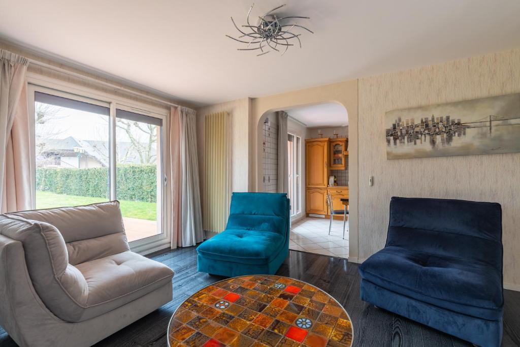 a living room with blue chairs and a table at Chez Laurent in Épagny