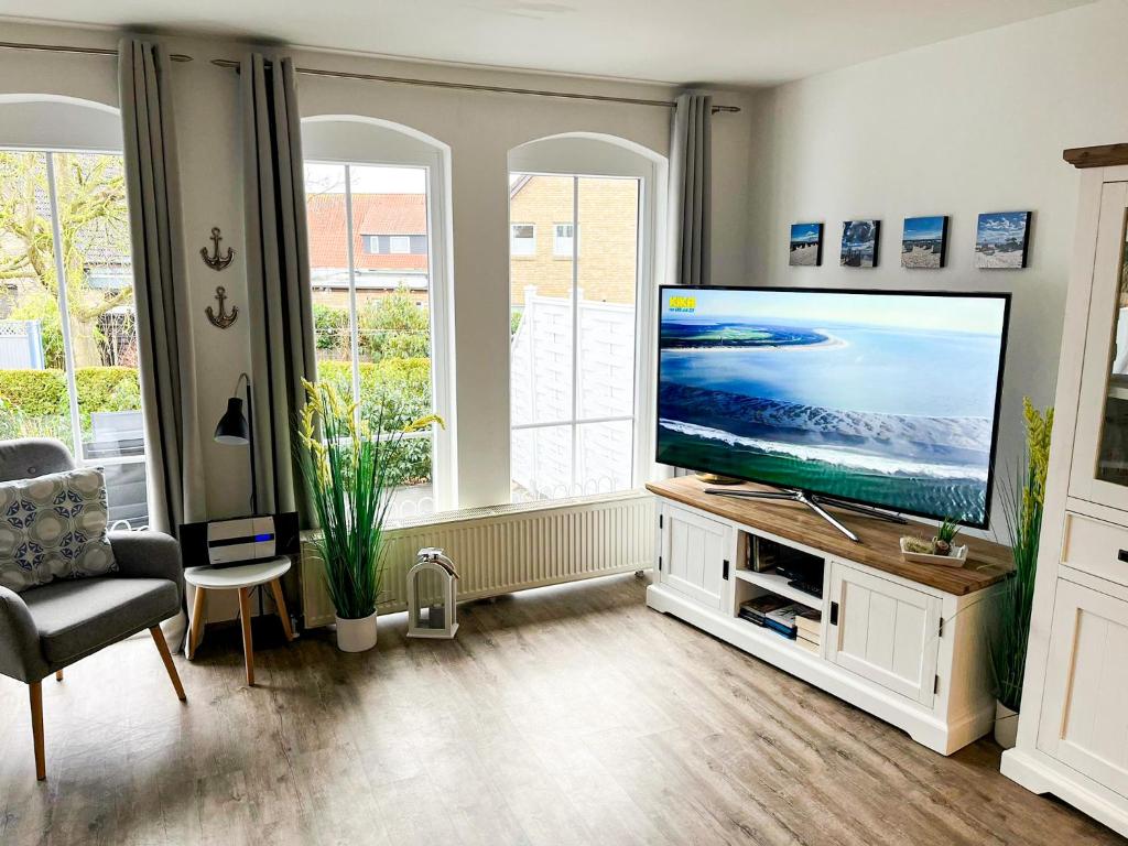 uma sala de estar com uma grande televisão de ecrã plano em Friesenhof 8H em Grömitz