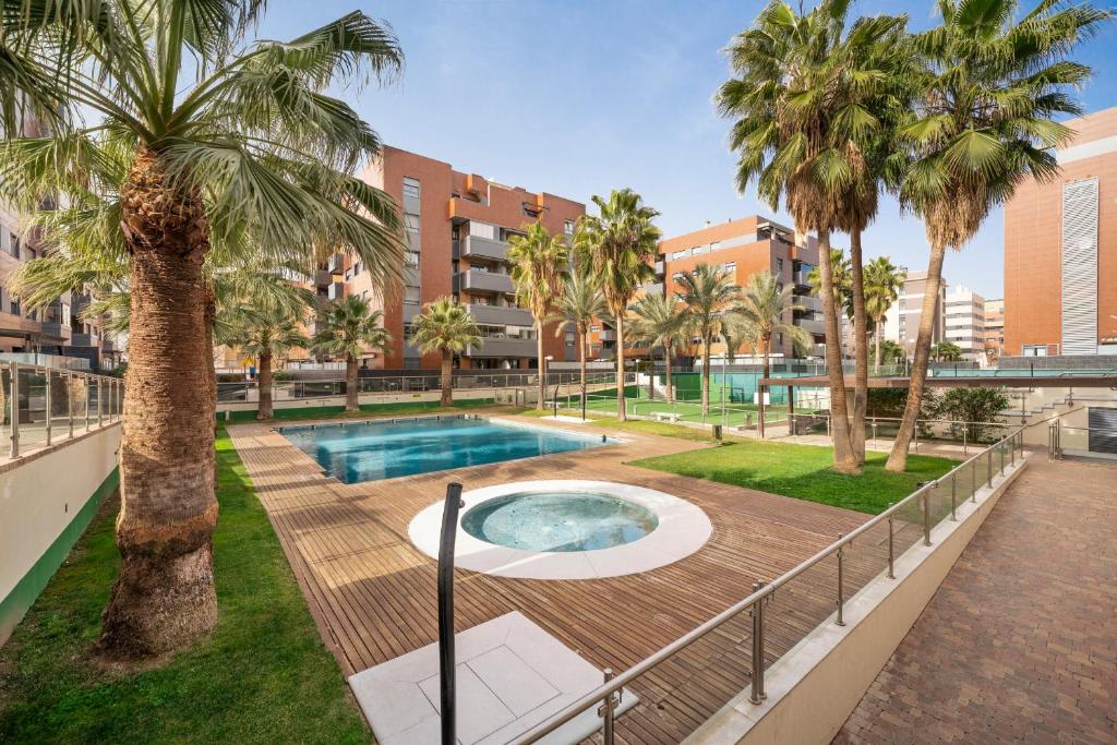 una piscina con palmeras en un parque en EnjoyGranada EMIR 4C + Parking, en Granada