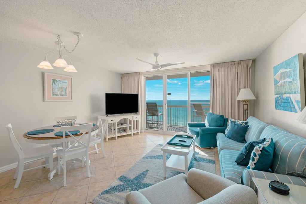 een woonkamer met een bank, een tafel en een televisie bij Pelican Beach 0805 by Pelican Beach Management in Destin