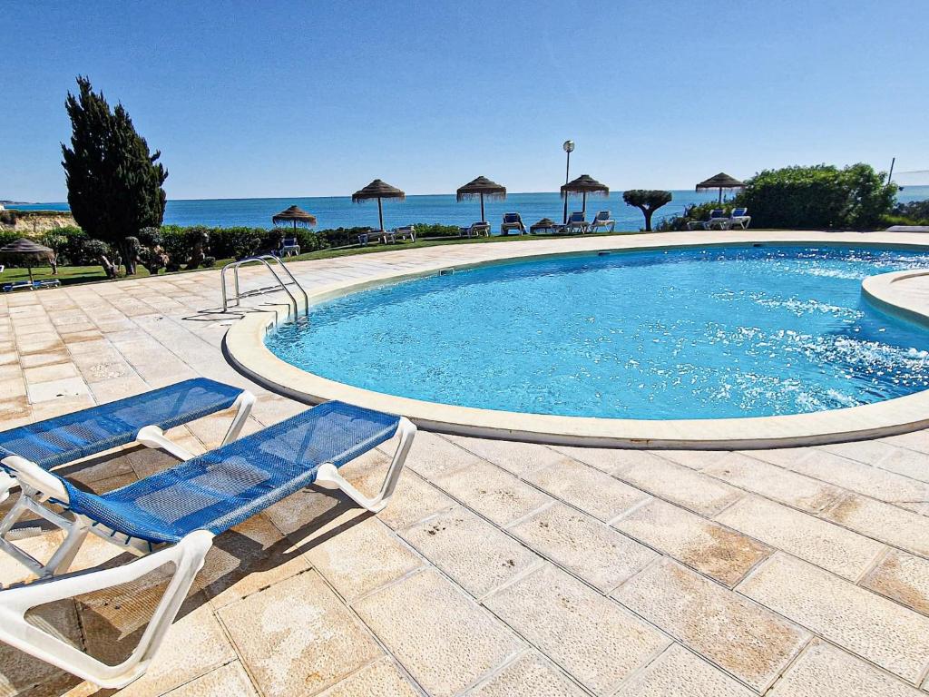 uma piscina com uma cadeira e um visorvisor em Vila Marrocha - Peace of heaven in Algarve - BY BEDZY em Armação de Pêra