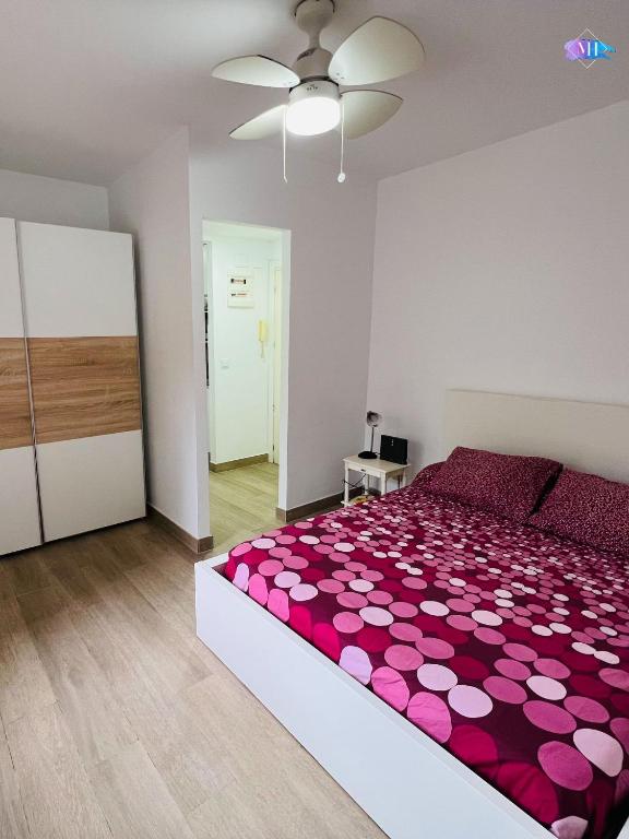 sypialnia z dużym łóżkiem i różowym kocem w obiekcie Apartamento Peñon de Ifach w mieście Calpe
