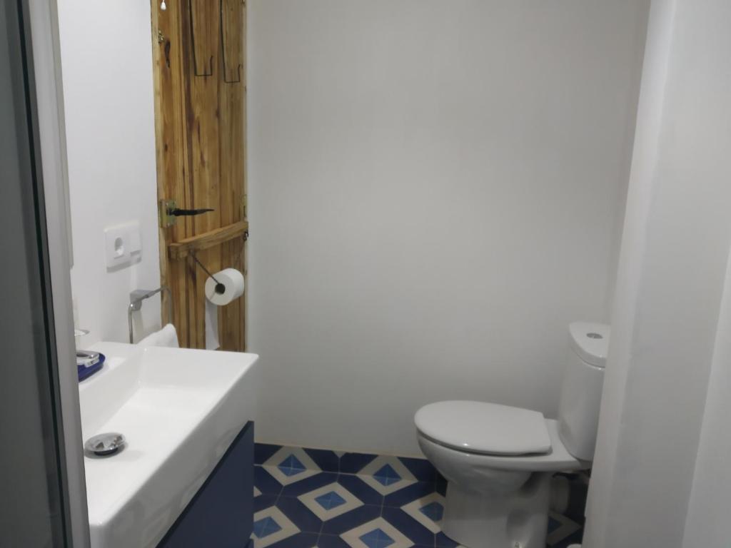 a bathroom with a white toilet and a sink at Casa Buscareta in Montán