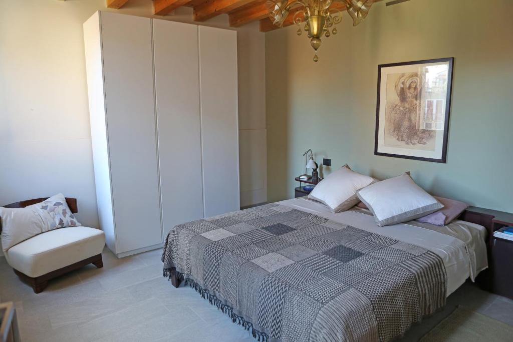 um quarto com uma cama grande e um lustre em Shuttered Dreams Murano Venice em Murano