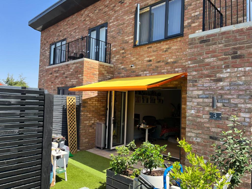 a patio with an orange umbrella in front of a brick building at Sevenoaks Centre Hideaway in Sevenoaks