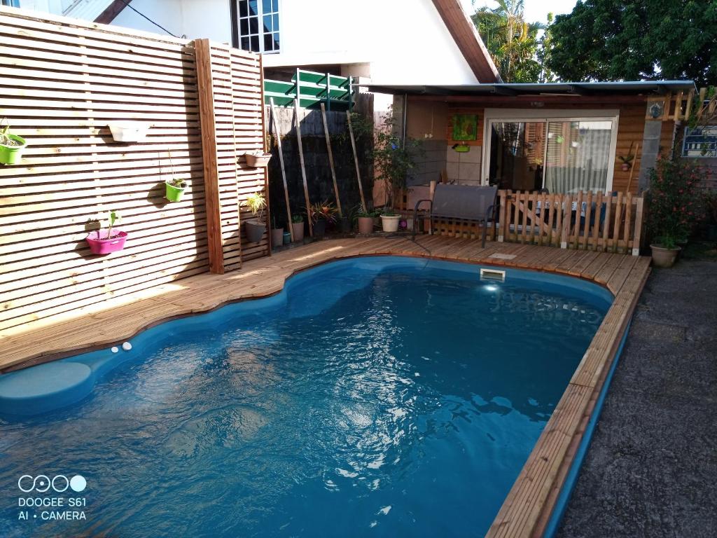una piscina en un patio trasero con una valla de madera en Chez Fred A Saint Andre, en Saint-André