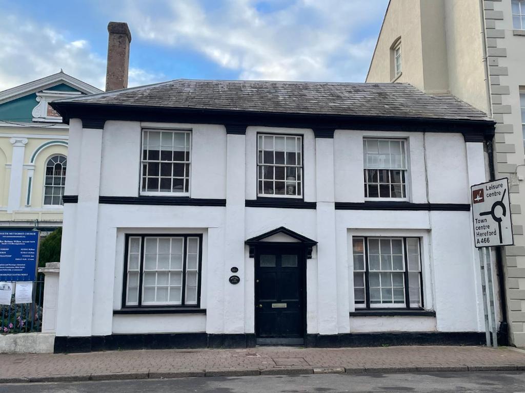 Biały dom z czarnymi drzwiami na ulicy w obiekcie The Hame w mieście Monmouth