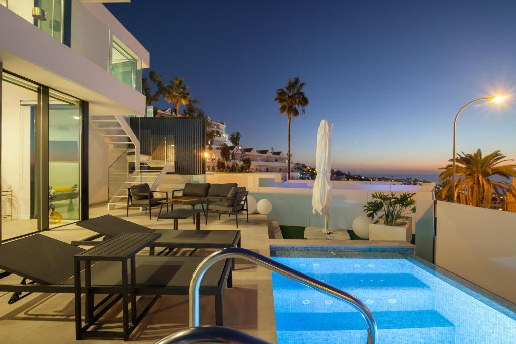 uma villa com piscina à noite em 200m NEW A Villa with private, heated pool and amazing ocean view em Adeje