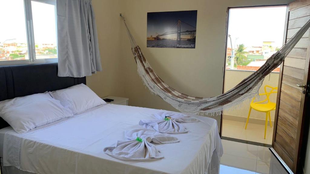 een slaapkamer met een hangmat en handdoeken bij Floripa Flat in Areia Branca