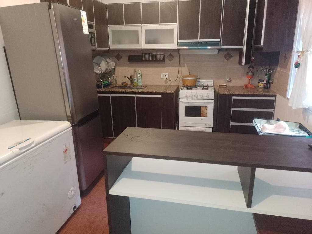 a small kitchen with brown cabinets and a refrigerator at Don Ricardo in San Salvador de Jujuy