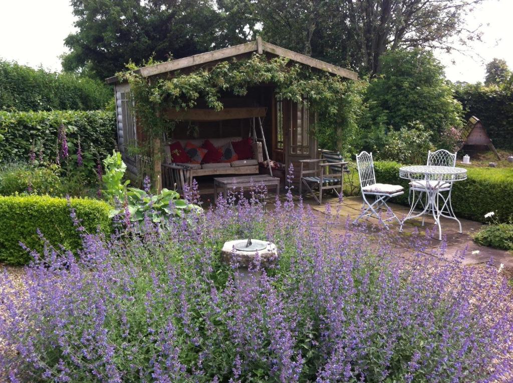 a garden with purple flowers and a gazebo at Rose Cottage in Tunstall