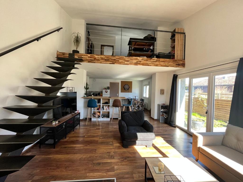 - un salon avec un escalier en colimaçon dans une maison dans l'établissement Superbe Loft, dégustations vignoble familial, à Villars-en-Pons