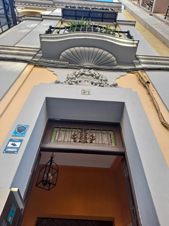 een deur naar een gebouw met een balkon bij Atico Duplex Marques de Reyes in Sevilla