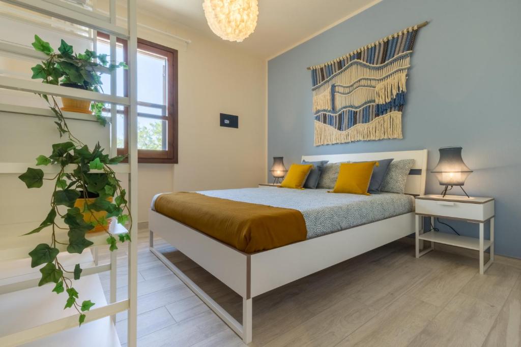 - une chambre avec un lit et des oreillers jaunes dans l'établissement 1 - Villa Is Orrosas - Apartments 1 - Sa Crai Apartments Sardinian Experience, à Lotzorai