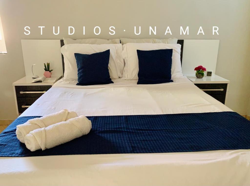 a bed with two towels sitting on top of it at Studios Unamar in Cabo Frio