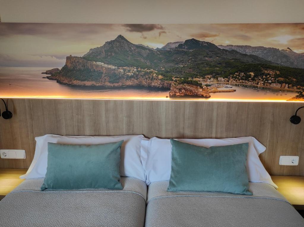 a bedroom with a bed with a painting on the wall at Hostal Nadal in Sóller