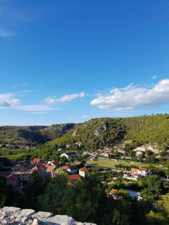 a view of a small town in the hills at MILDA+M in Skradin