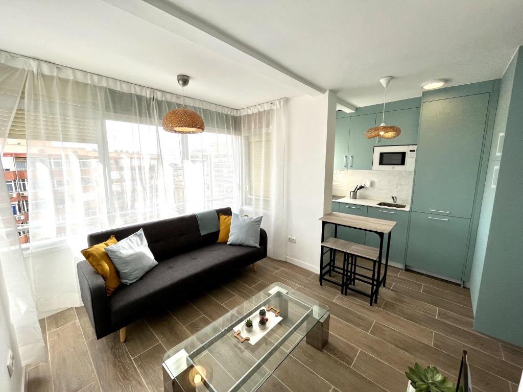 salon z czarną kanapą i stołem w obiekcie TAR11D - Estudio con Vistas al mar, Wifi, Smart TV, Fire Stick Amazon, en el Centro, a 600 metros Playa w mieście Torremolinos
