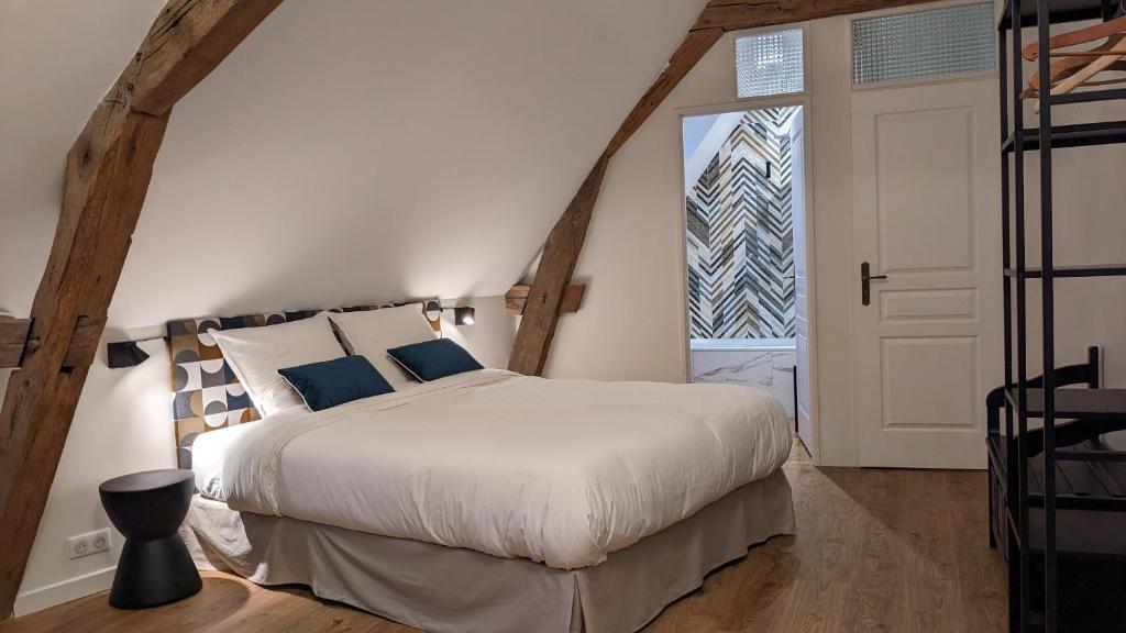 ein Schlafzimmer mit einem großen Bett und einem Fenster in der Unterkunft Le 14 Faubourg in Beaune