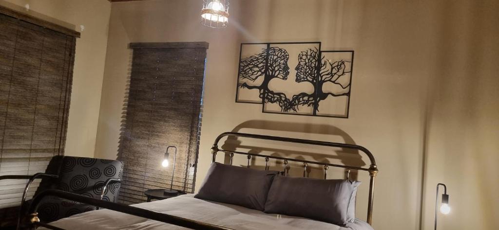 Un dormitorio con una cama y dos cuadros en la pared. en Rand Self-catering Accommodation, en Carolina