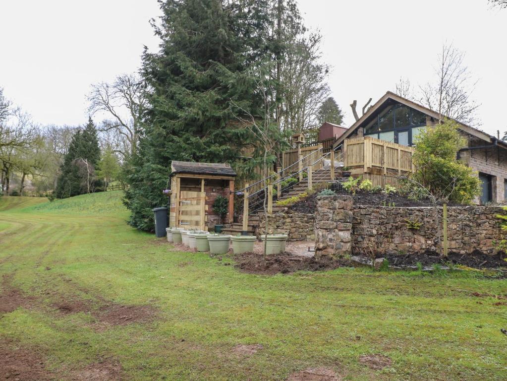 a house with a garden and a stone wall at Stoney Rock Studio in Waterfall