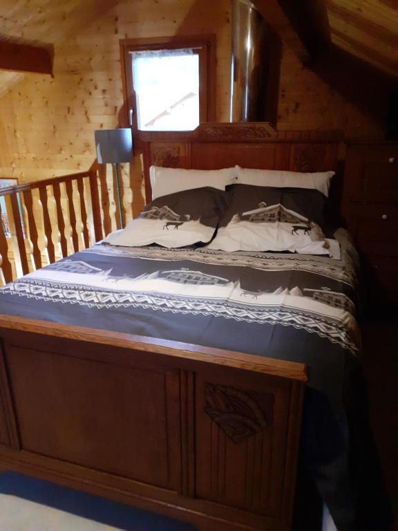 een bed in een houten hut met een raam bij chalet des Greunnouilles in Xonrupt-Longemer