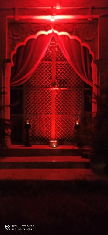 a red room with a stage with a red curtain at Queen Room @ Shangri-Li in Jodhpur