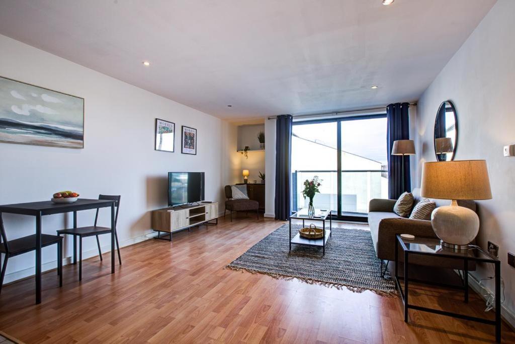 a living room with a couch and a table at Stylish 2 Bedroom Apartment on the Waterfront in Ipswich