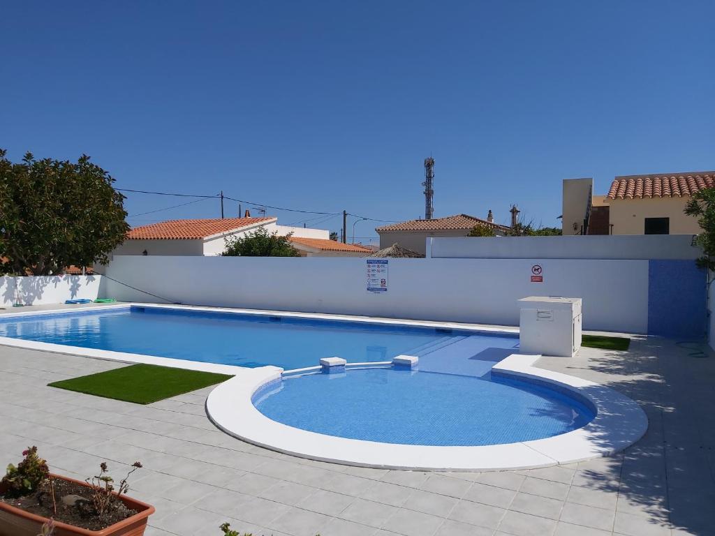 una gran piscina junto a un edificio blanco en Tramontana Villa en Cala'n Porter