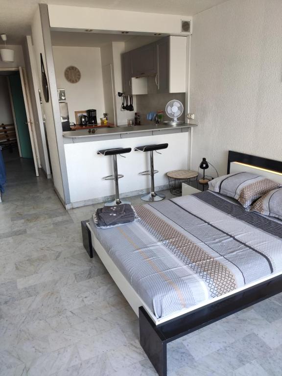 ラ・グランド・モットにあるStudio LE FIDJI - A 5m du centre - Face au Port - Parking Privéのキッチン付きの客室の大型ベッド1台分です。