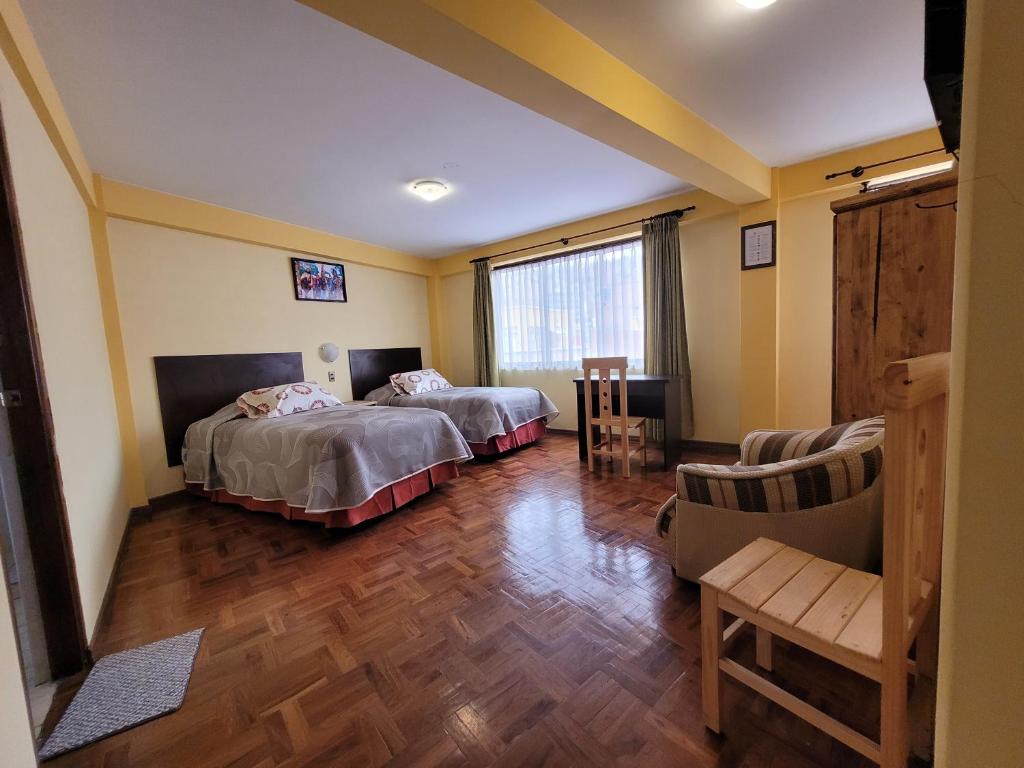 a hotel room with two beds and a chair at Hotel Nuevo Sol in La Paz
