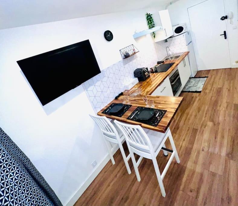 a kitchen with a table and two white chairs at Joli studio entièrement rénové et équipé classé 2 étoiles in Balaruc-les-Bains