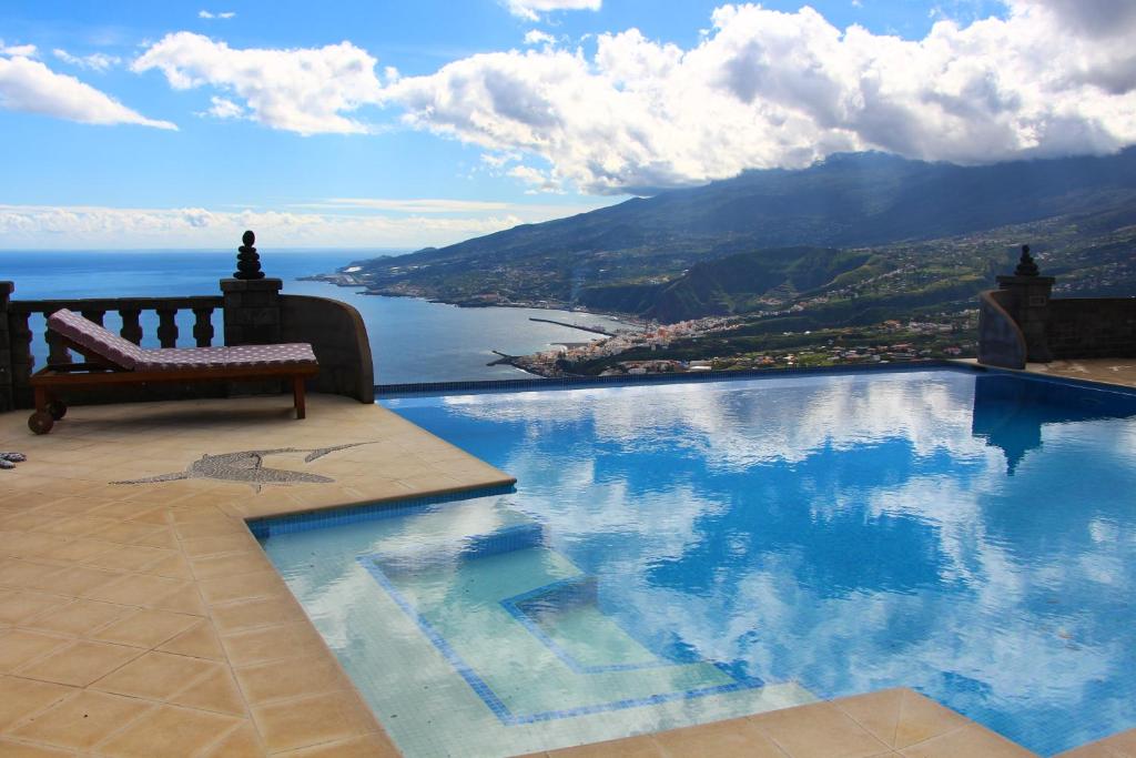 a swimming pool with a bench and a view of the water at Casa Vista Pájaro in Puntallana