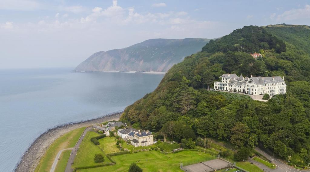 an aerial view of a house on a hill next to the water at Tors Park in Lynmouth