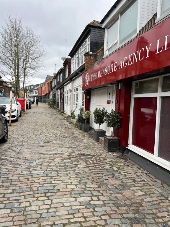 a cobblestone street in a city with buildings at Studio flat in the heart of Golders Green in London