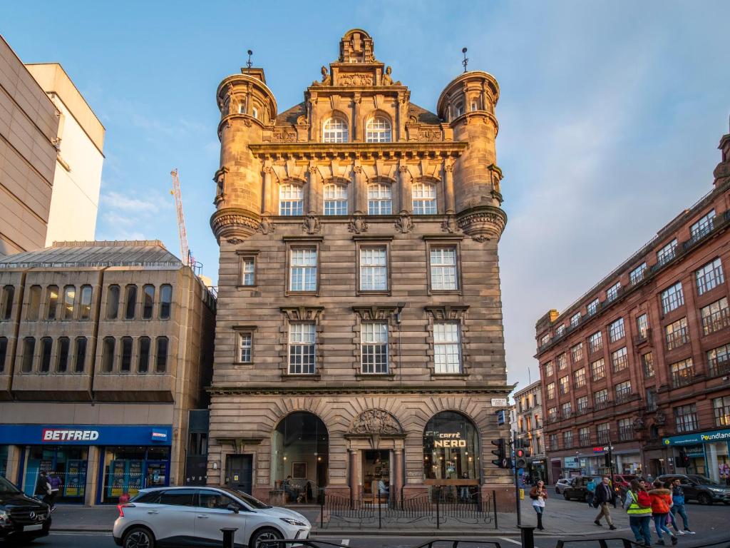 a large building with a tower on a city street at Glassford Residence in Glasgow