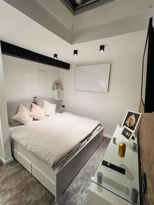 Schlafzimmer mit einem Bett, einem TV und einem Tisch in der Unterkunft Bezauberndes Apartment im Herzen von Nieukerk. in Kerken