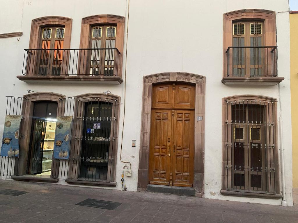 um edifício branco com duas portas e duas janelas em Casa Centro By Lofts 48 em Querétaro